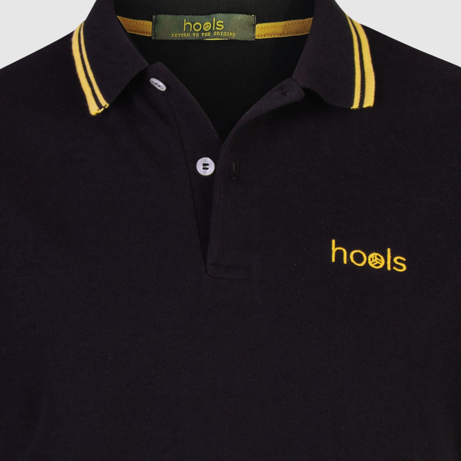 Detalle del cuello y etiqueta interior del polo Hools negro con rayas amarillas