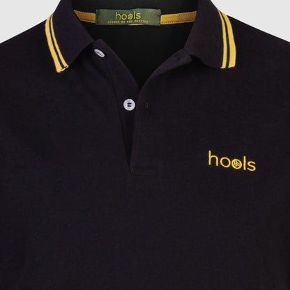 Detalle del cuello y etiqueta interior del polo Hools negro con rayas amarillas