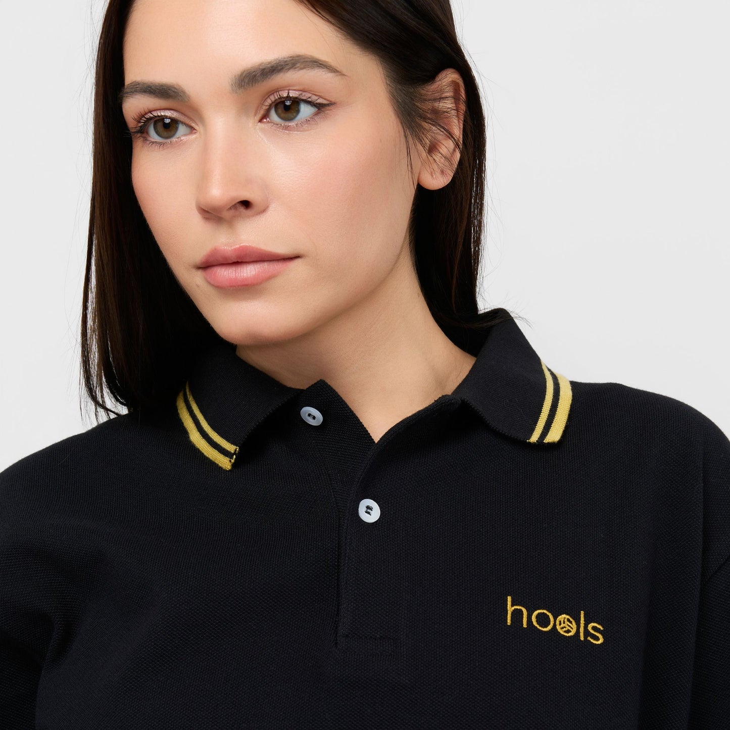 Polo Hools negro con rayas amarillas llevado por modelo mujer
